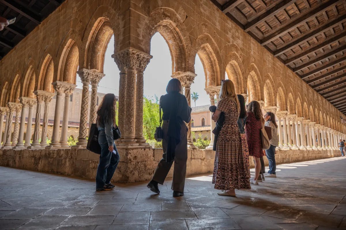 group of women looking at historic archways in building courtyard