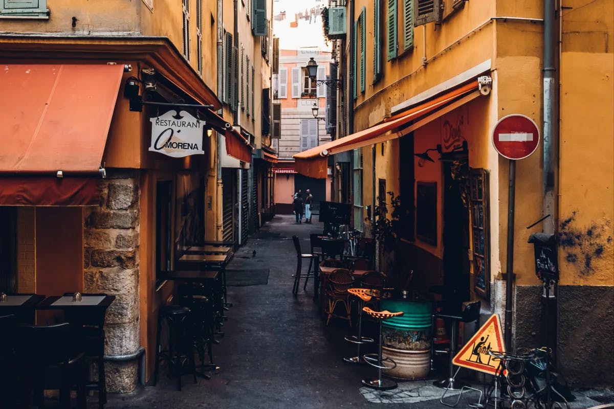 A local restaurant on a small, side street, and old buildings inside of Aix-en-Provence's Old Town.