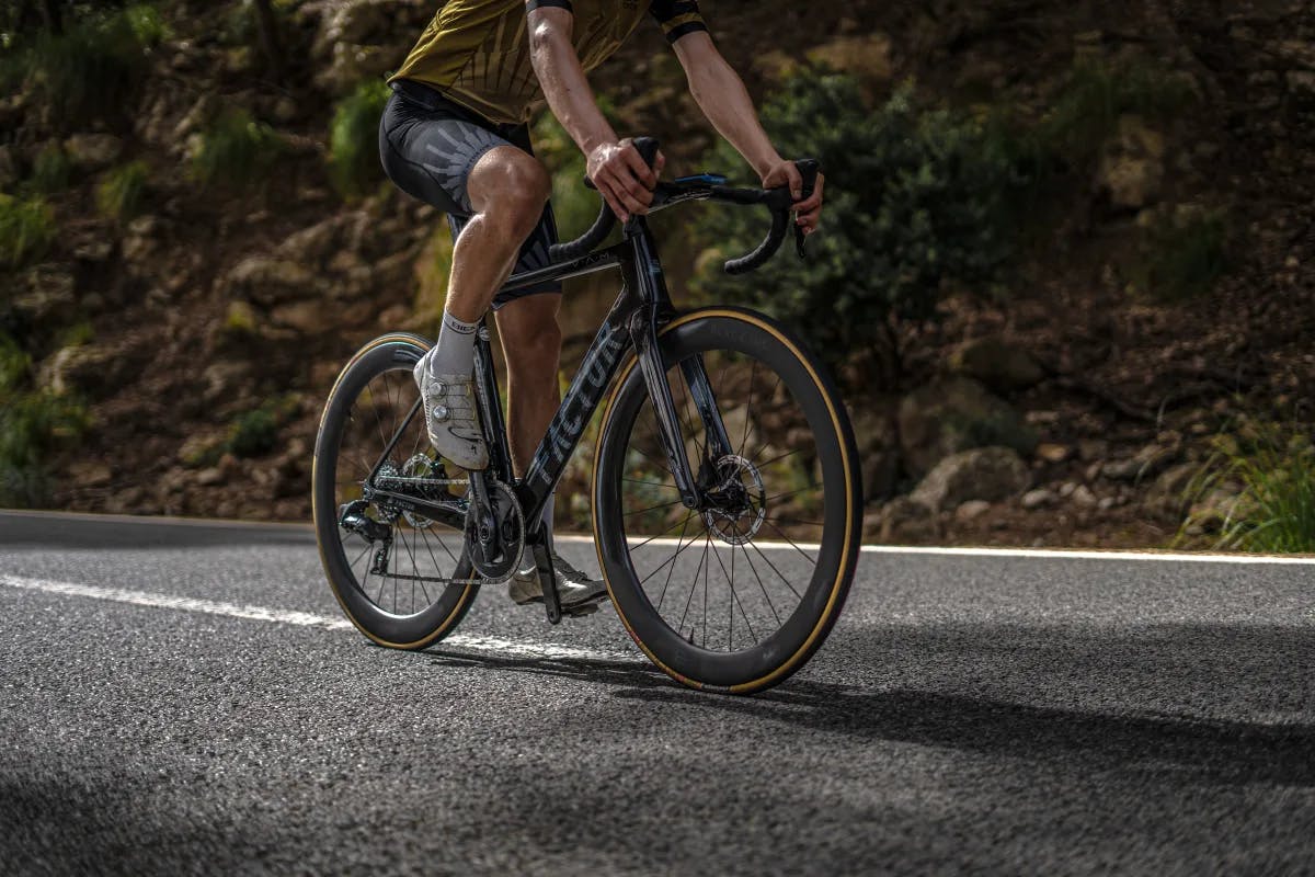 A picture of a man cycling on a road during daytime