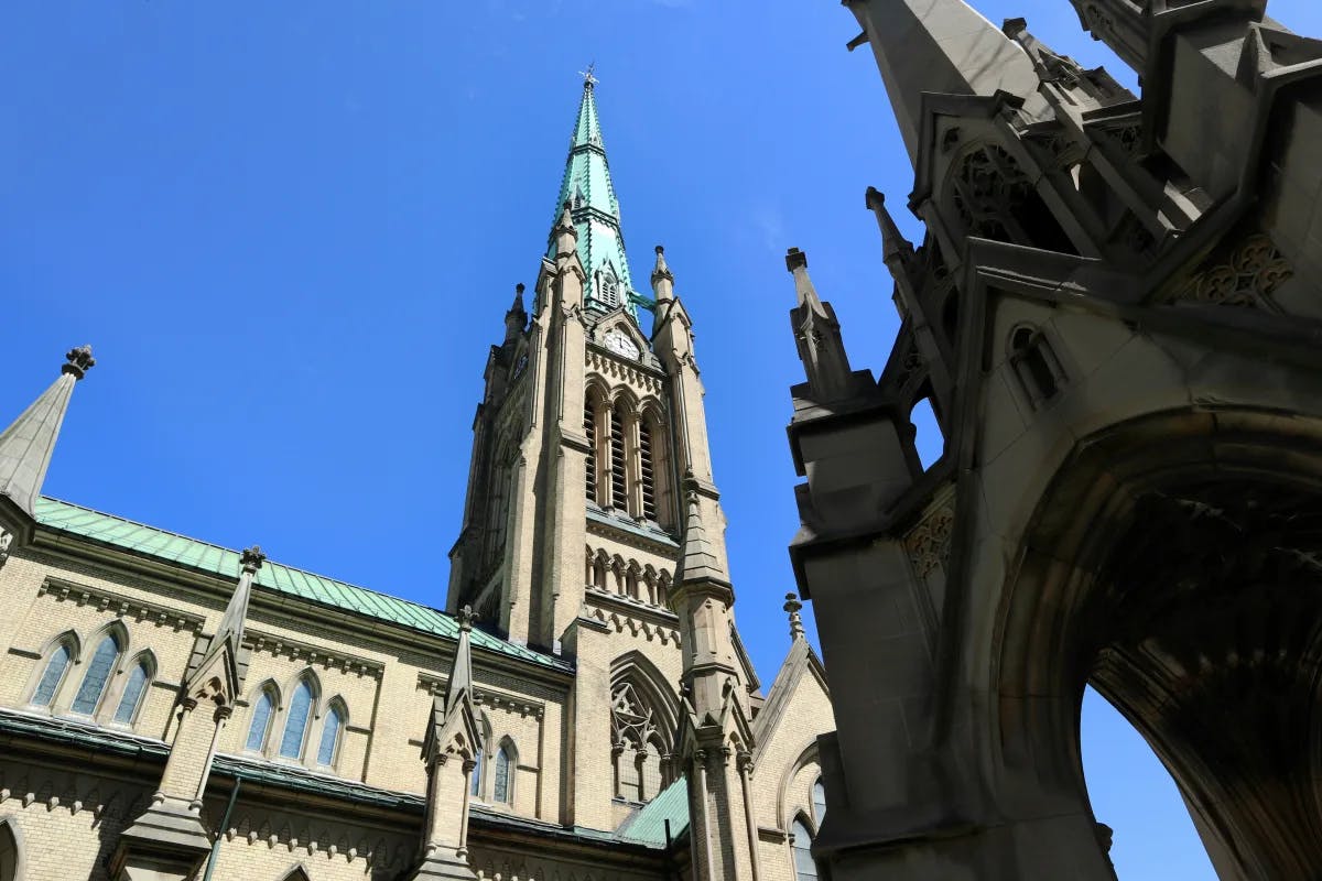 A low-angled view of a cathedral in Toronto against a blue sky.