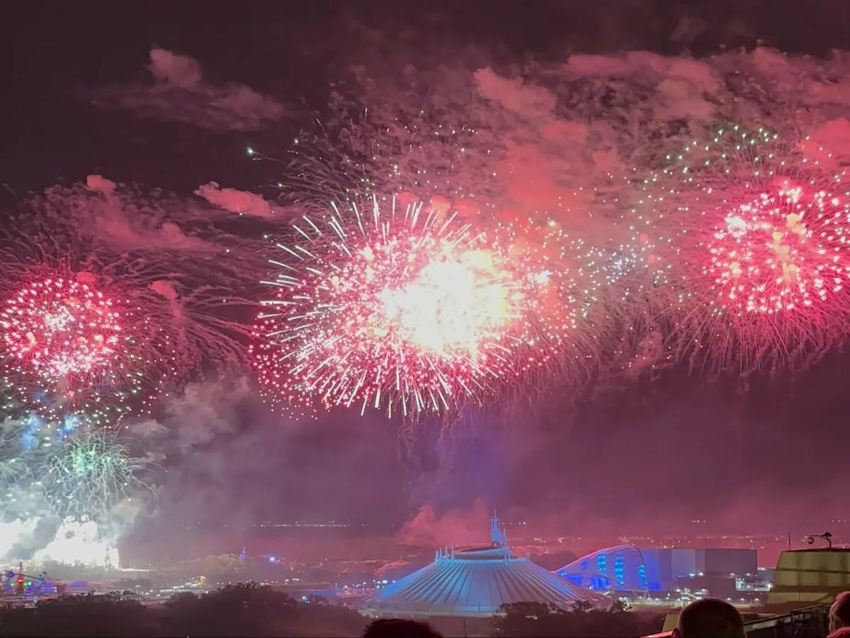 A picture of fireworks in the sky during nighttime over Disney World.