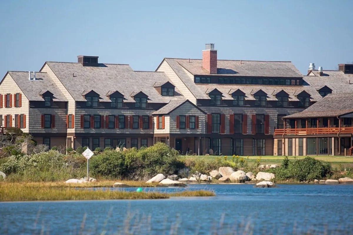 shingle building with red shutter on the water