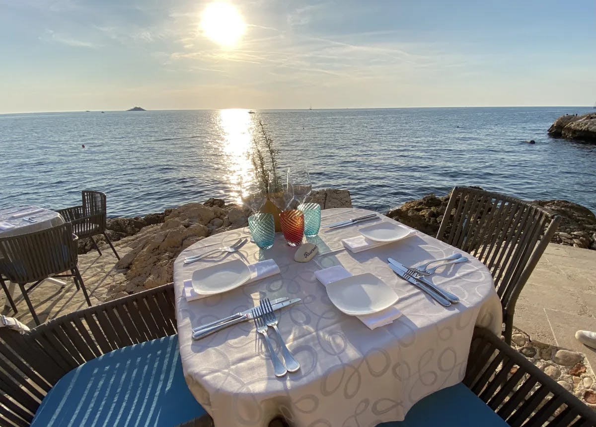 Beach side outdoor restaurant with people sitting and eating.