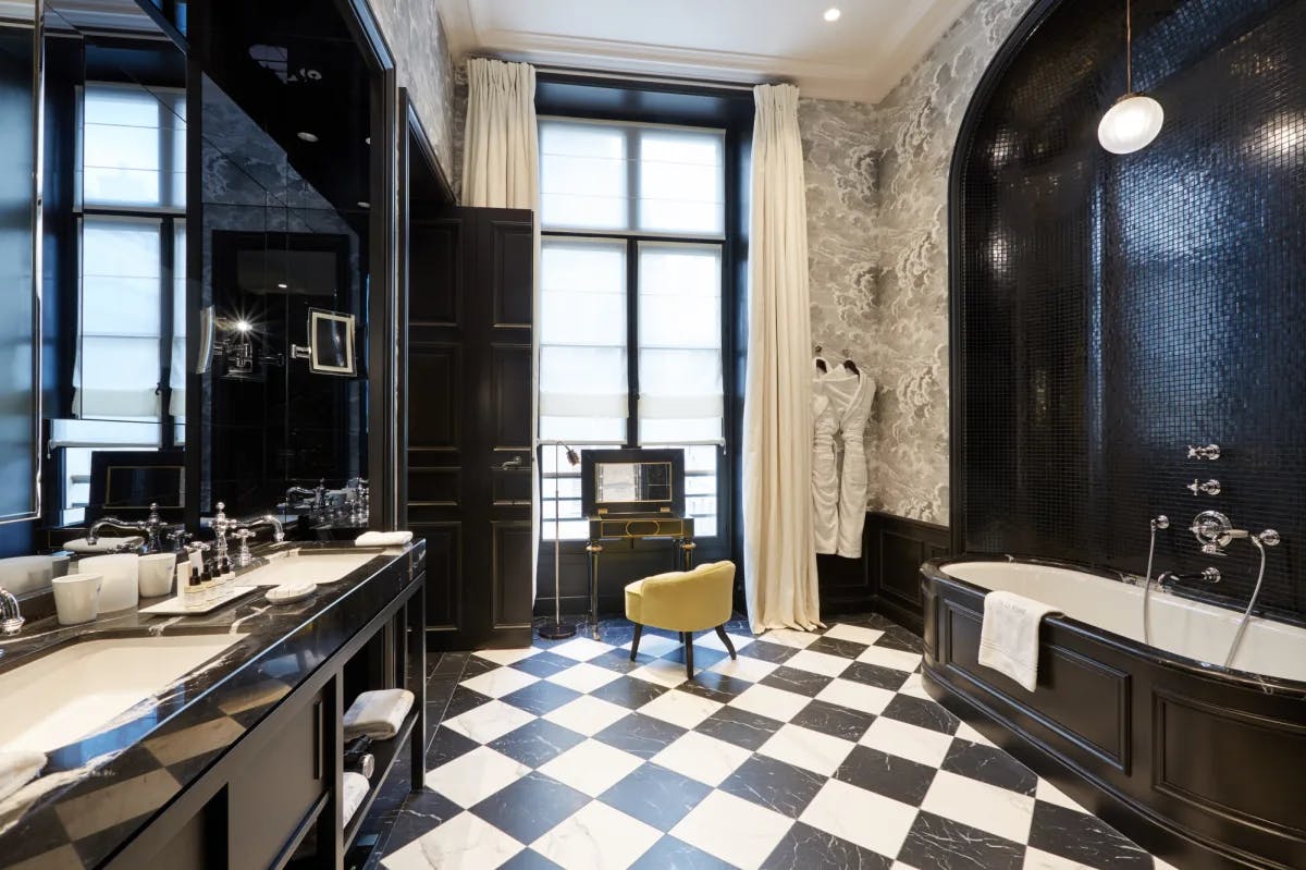 a giant bathroom with black tiled walls and black-and-white checkered tile floors