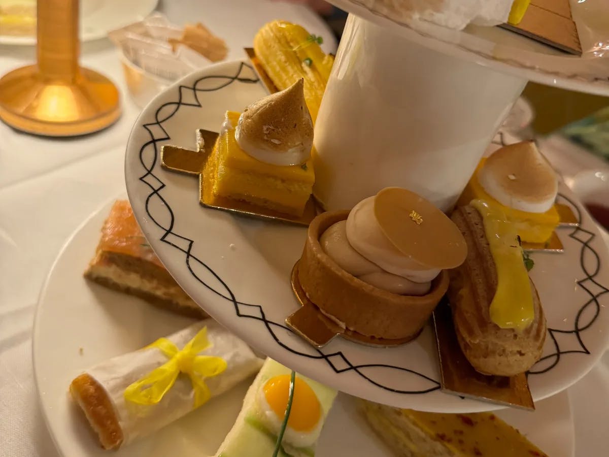 An aerial view of a variety of snacks as part of afternoon tea served on white ceramic crockery at a restaurant.