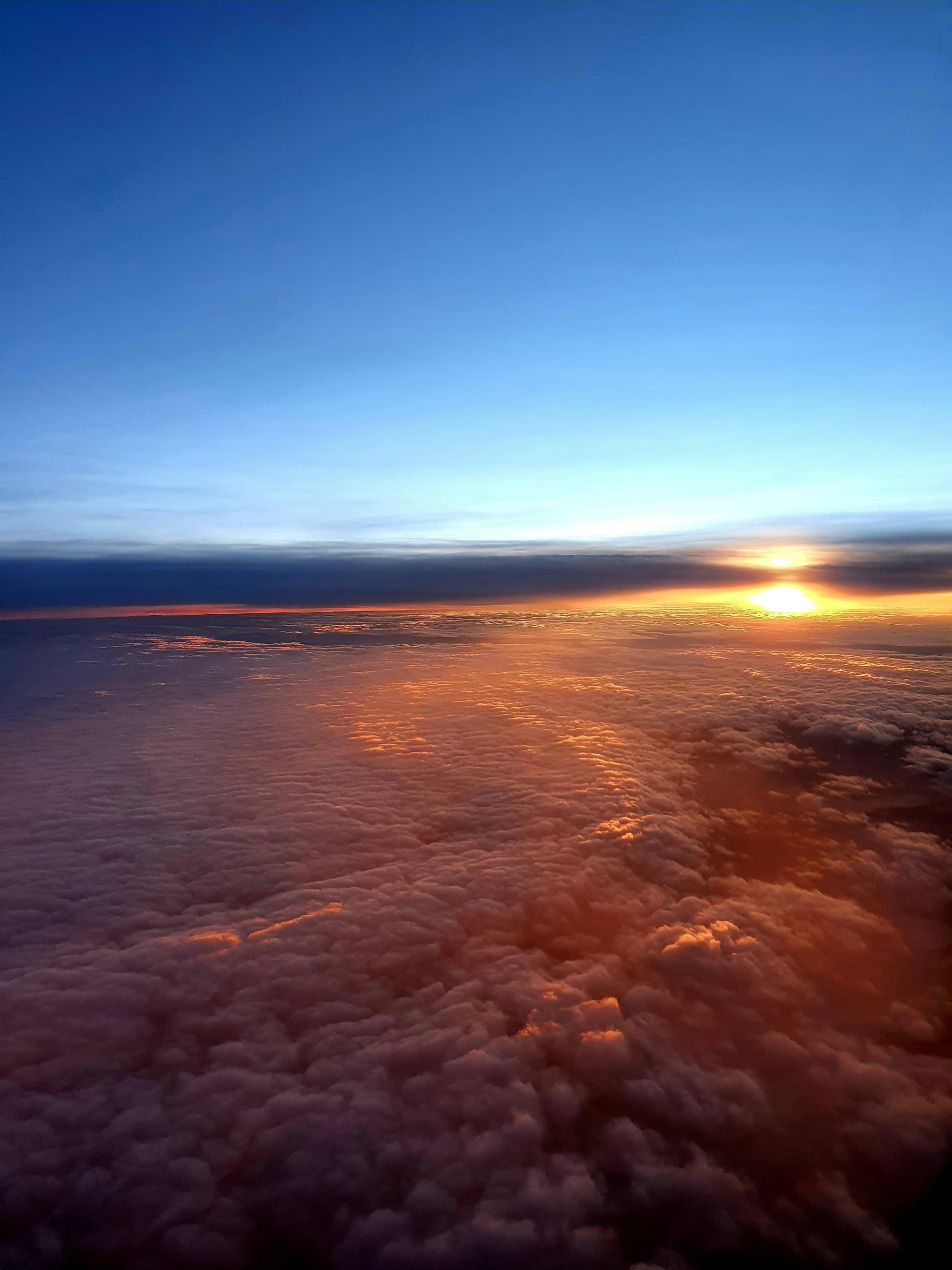 The sun setting over clouds