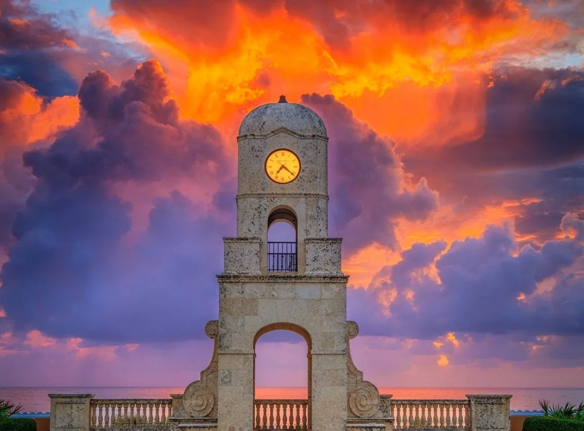 Worth Ave Clock Tower with a beautiful sunset and palm trees