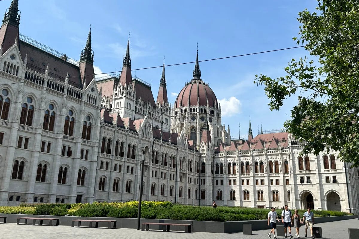 Hungarian Parliament Building during the day - a large ornate white building with domed red roofs.