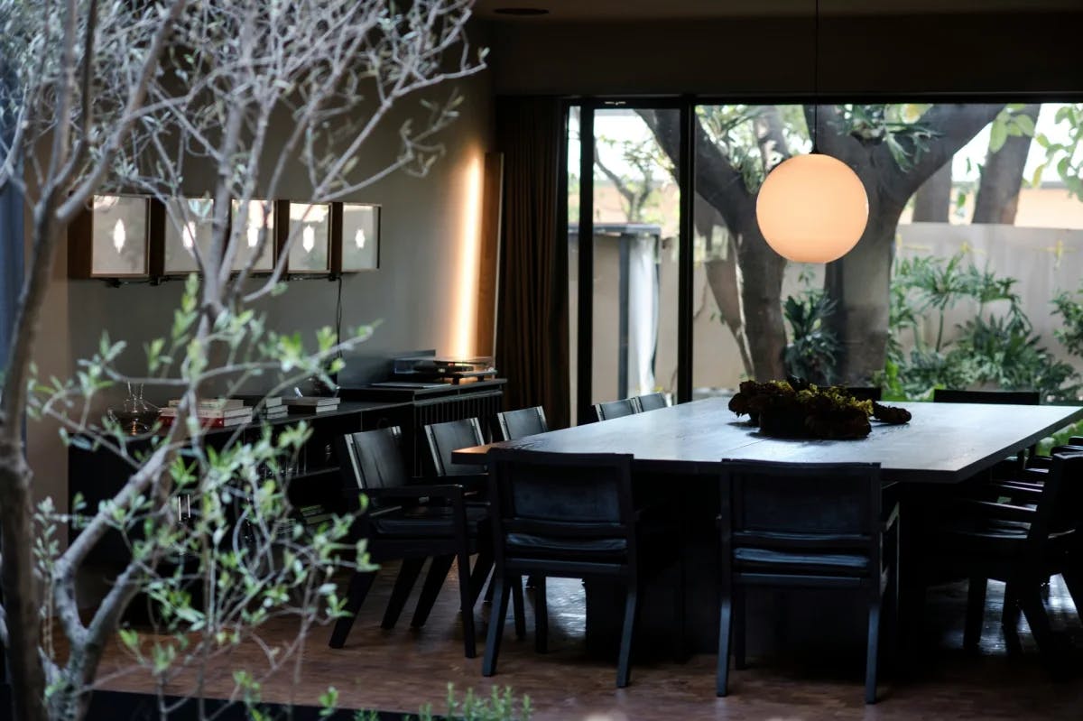 a square wooden table surrounded by black chairs in a sleek restaurant dining room