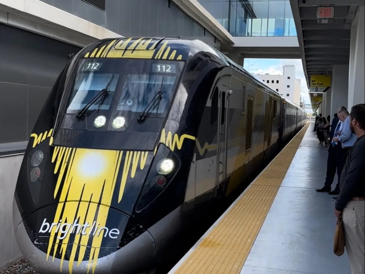 A black train arriving at a station. 