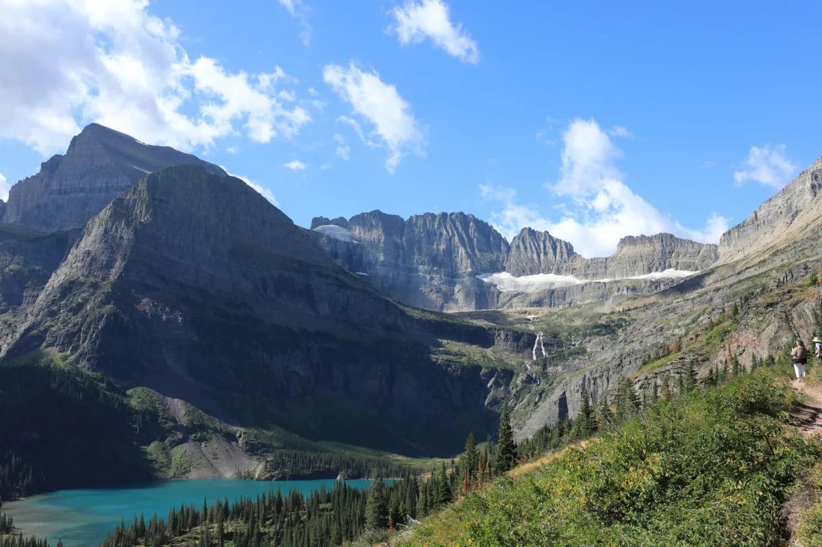 rocky mountain peaks and a blue sky and a crystal blue alpine lake