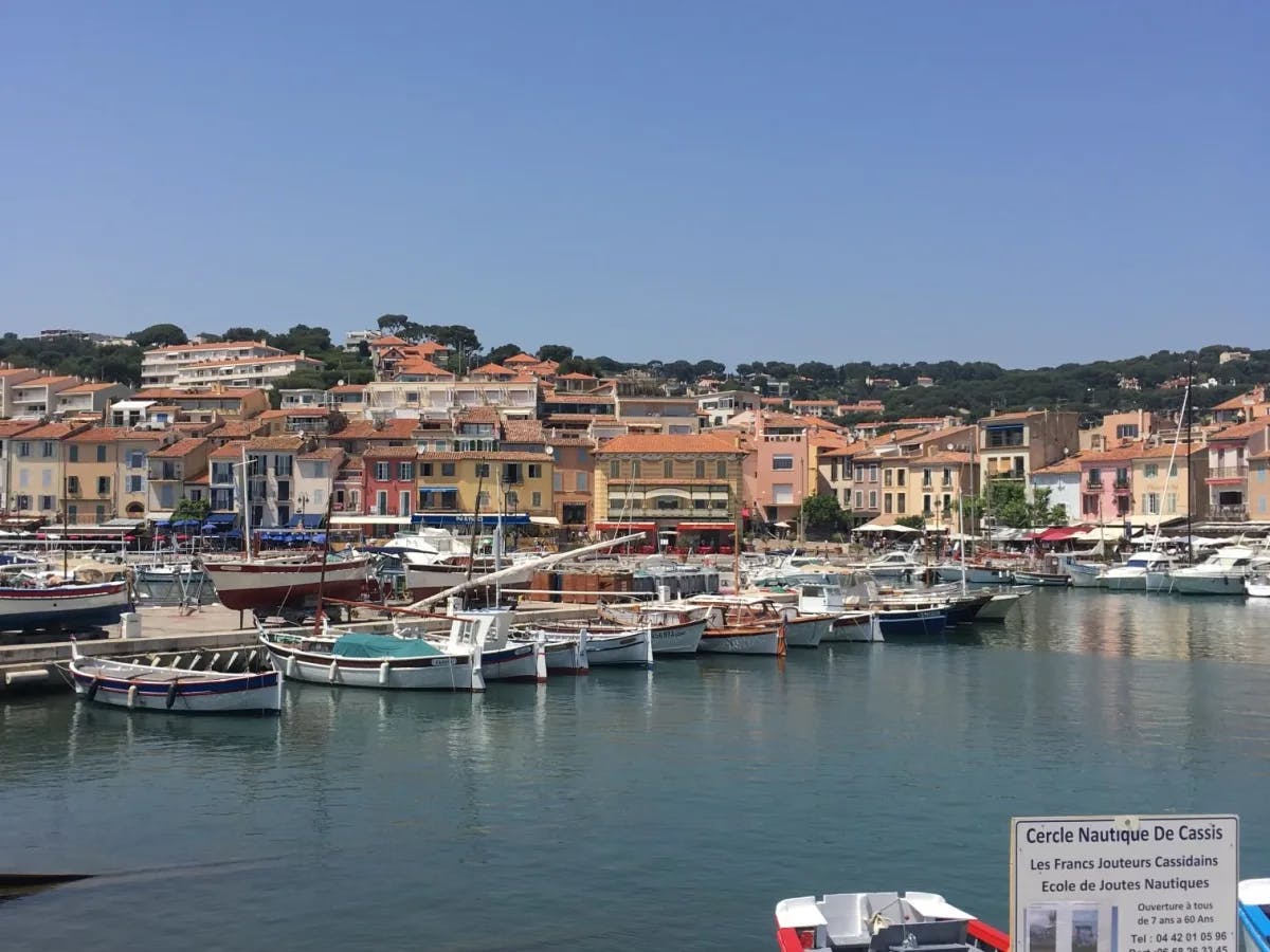 A beautiful dock with multiple fishing boats and houses along the shore. 