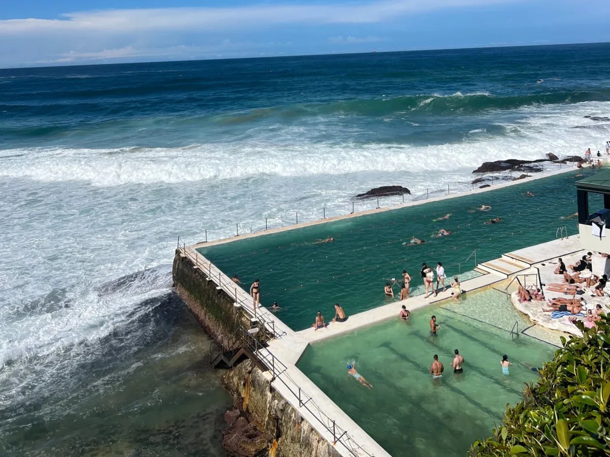 Public infinity pools carved into rocks over the ocean.