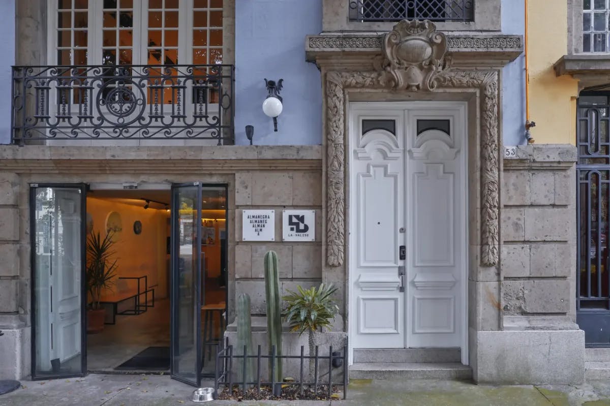 a white door on an old baby-blue city façade