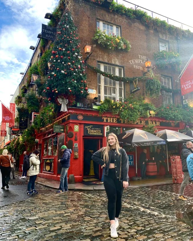 Advisor posing on bustling street corner decorated for the holidays. 