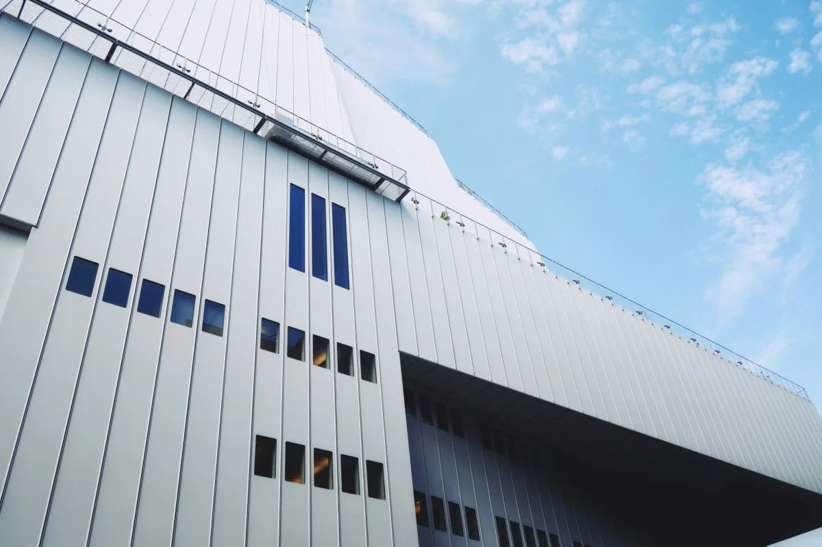 a modern gray building exterior against a blue sky