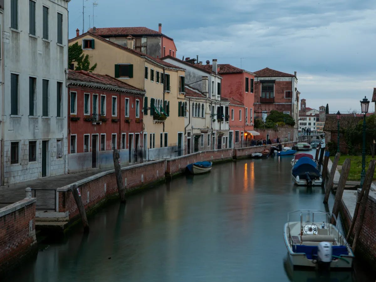 A picture of a river running through a city, next to tall buildings during daytime.