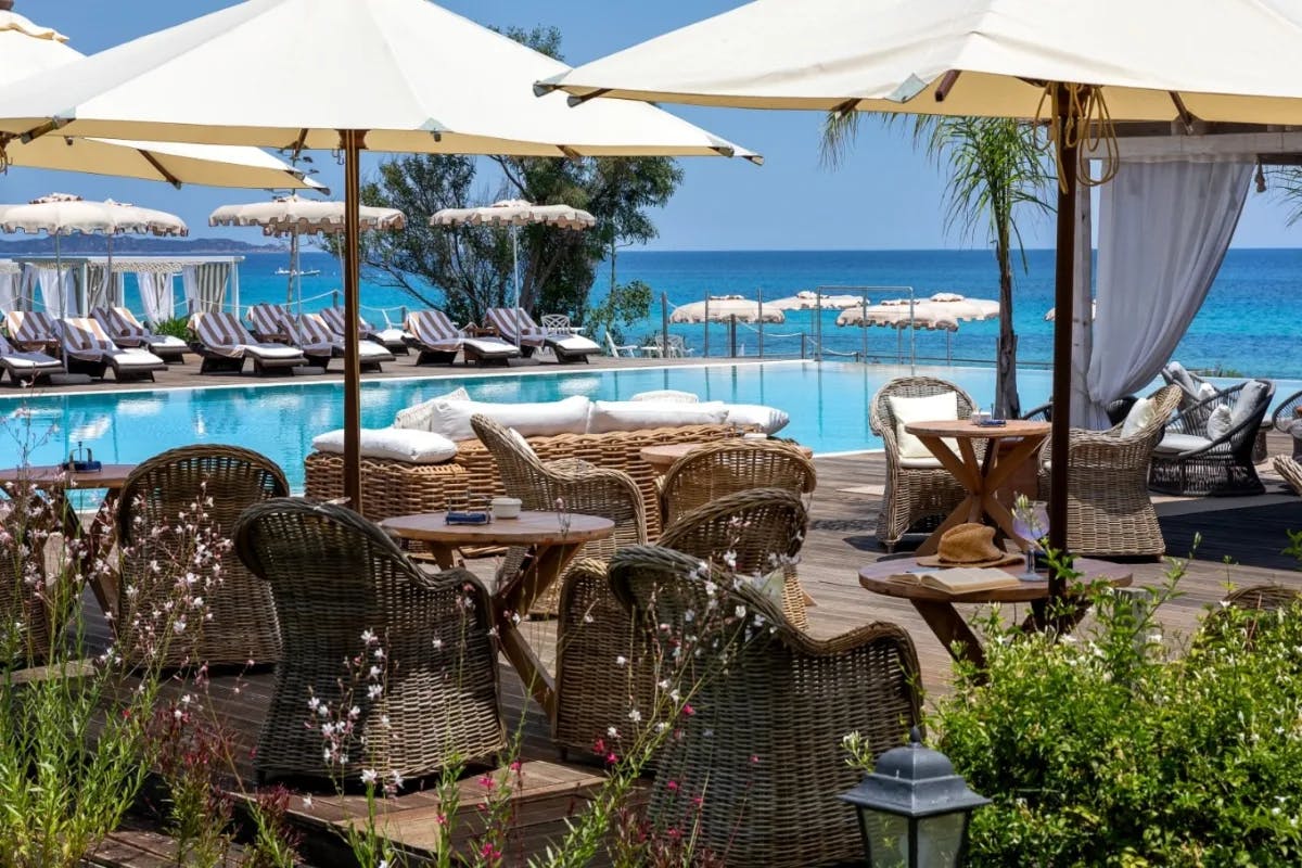 pool deck with white umbrellas and the sea beyond