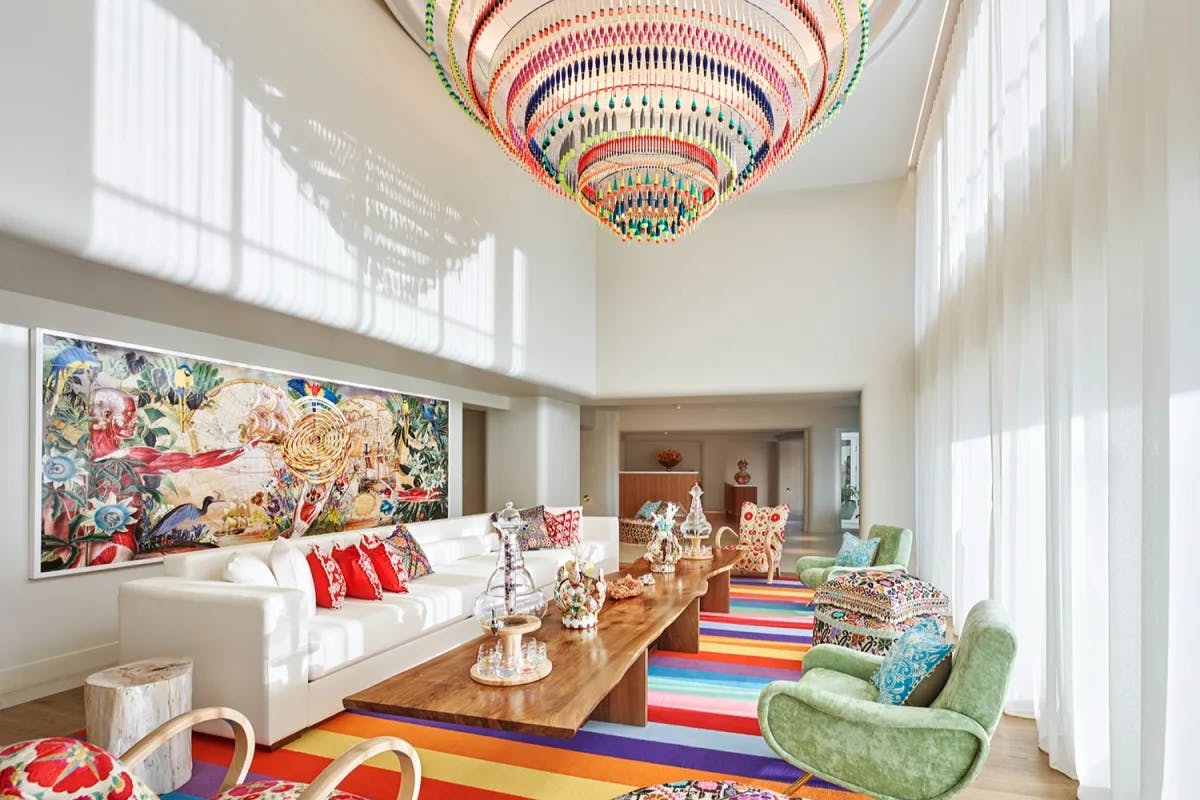 airy lobby room with rainbow carpet and colorful chandelier