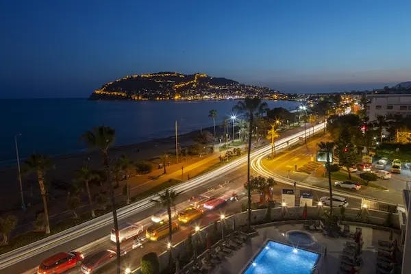 View of the bustling city and lights along the shore at dusk. 