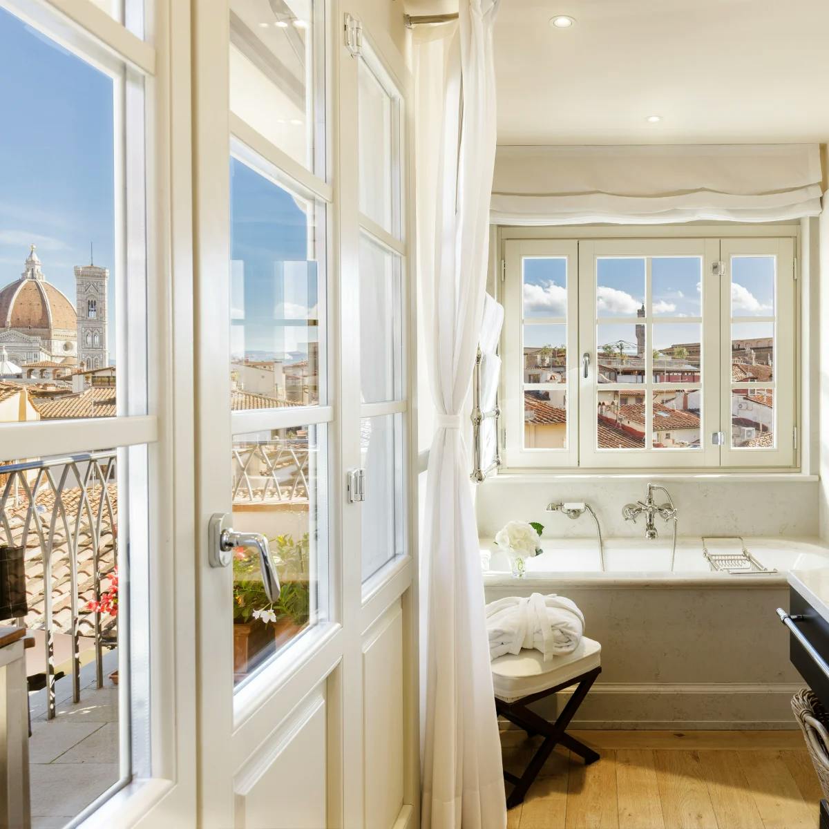 A view of the Duomo from a suite in a bathroom, with marble fixtures and wood floors.