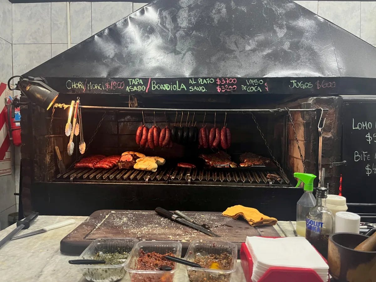 A BBQ grill with sausages and meat. 