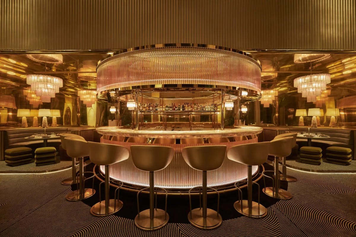 golden glowing bar with curved counter and bar stools