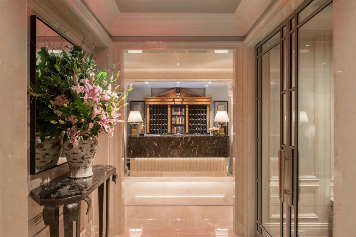 a hallway with a large bouquet of flowers leading up to a hotel front desk