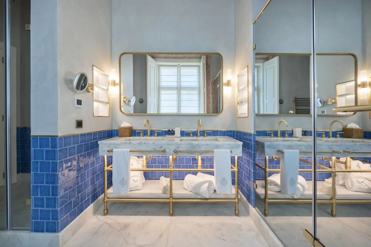 a fancy bathroom with a marble vanity and blue tiles