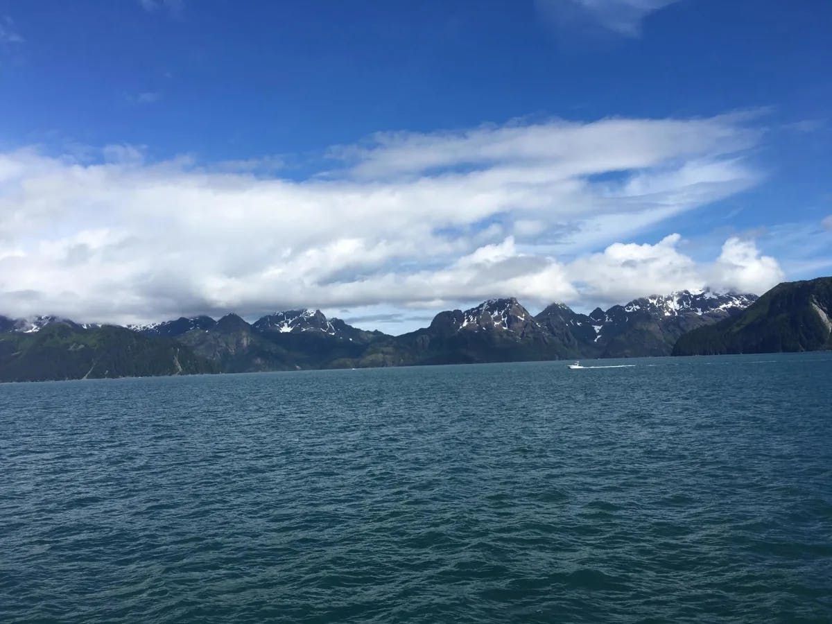 A water body with snow covered mountains at the back. 