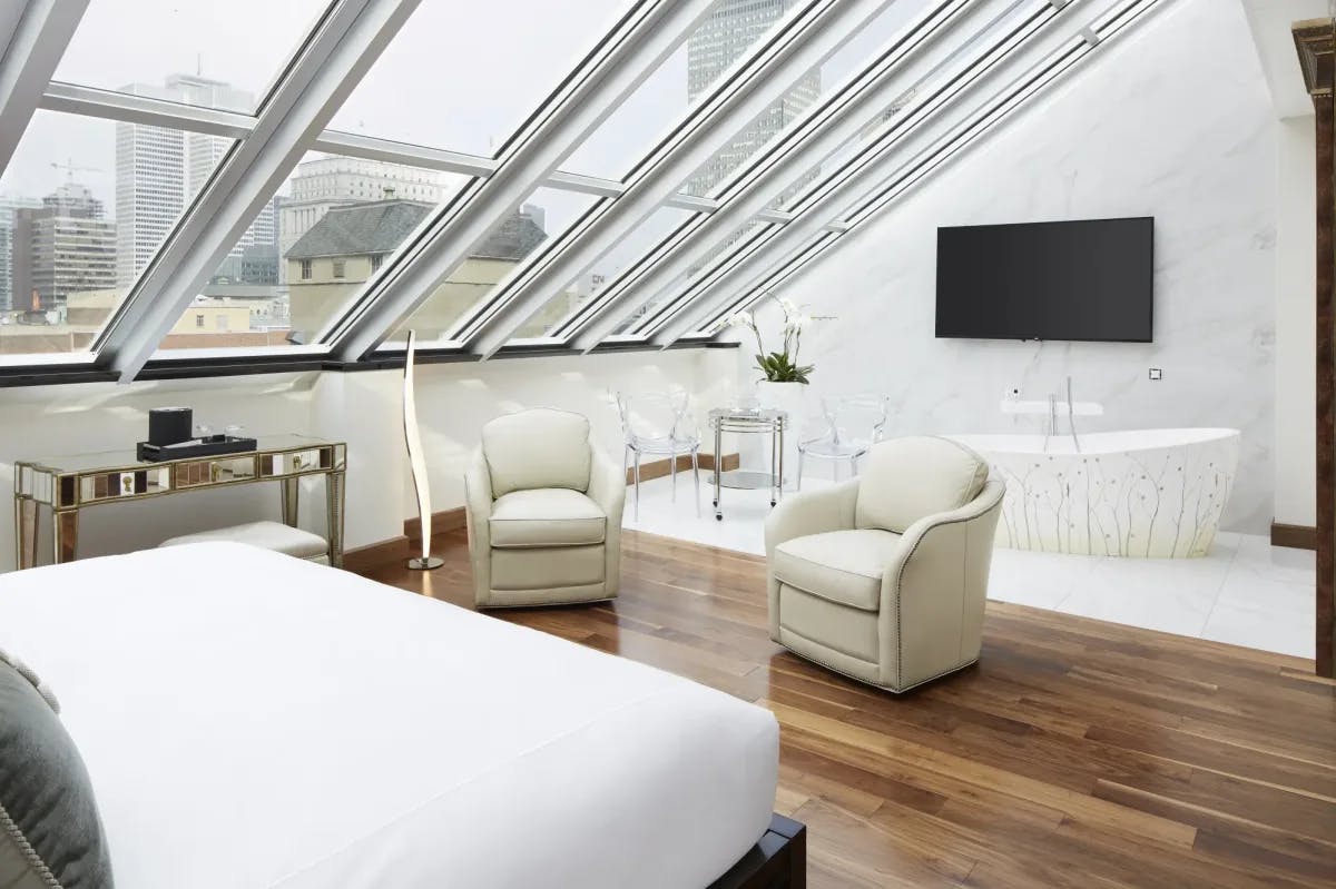 a whitewashed bedroom under a slanted glass roof