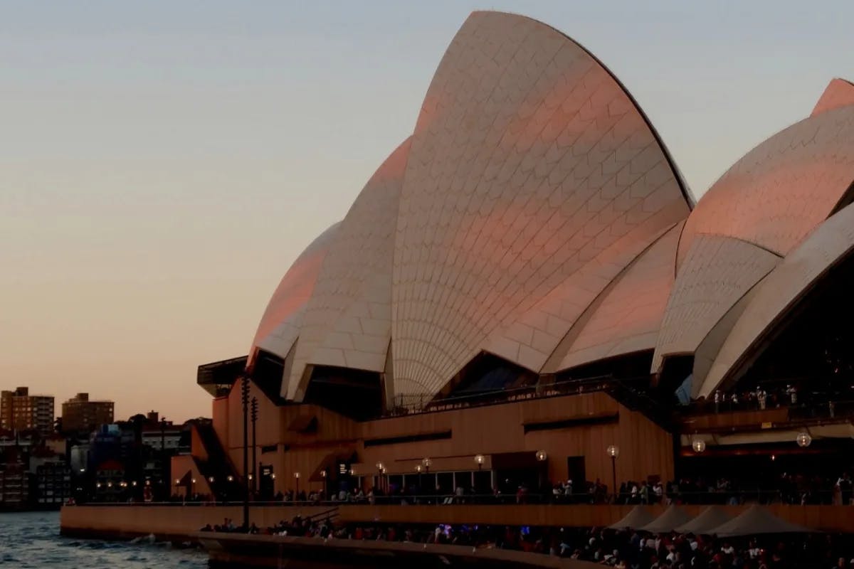 A view of the iconic Sydney Opera House at sunset.