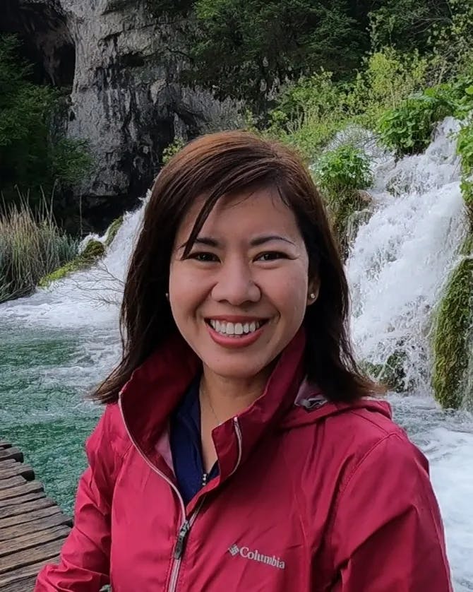 Travel advisor posing beside waterfall