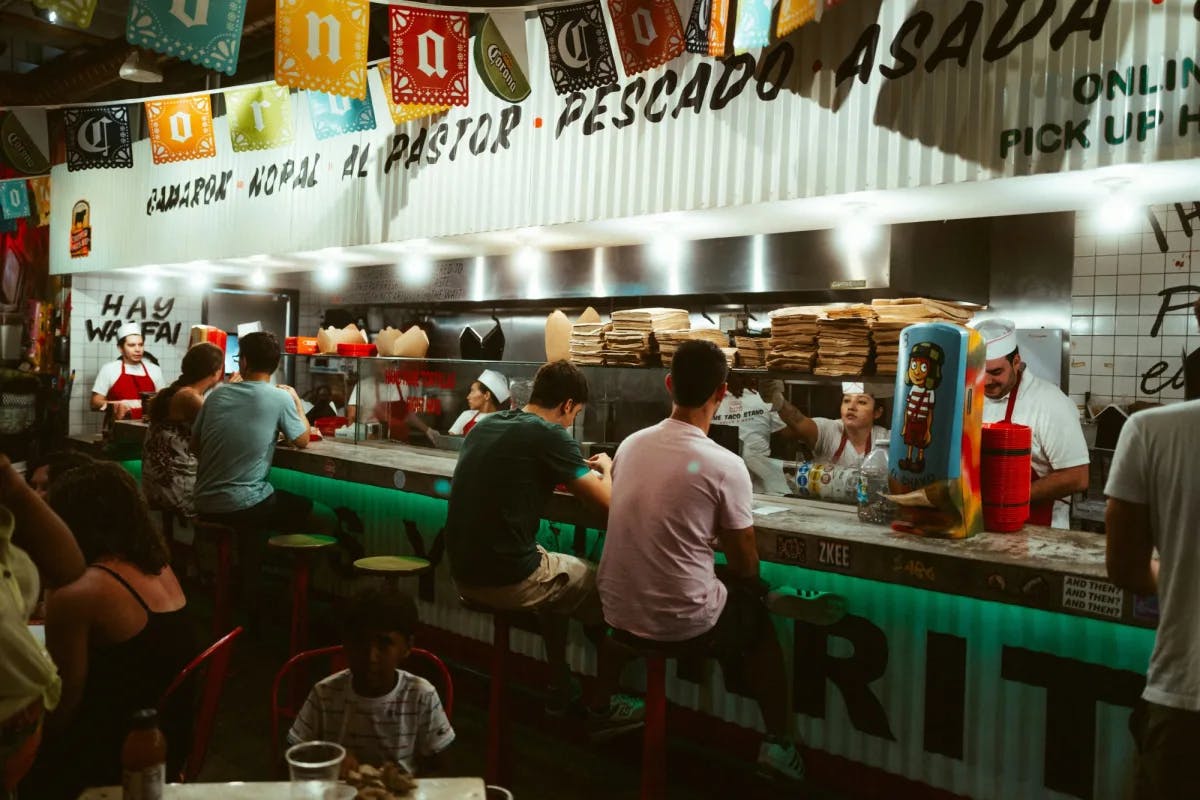 A group of people is sitting at a counter in a restaurant.