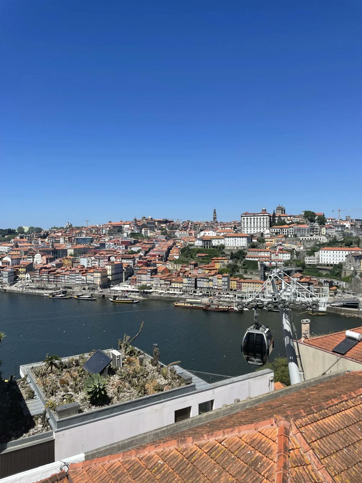 A view of Porto and its river from a rooftop or balcony on a sunny day.