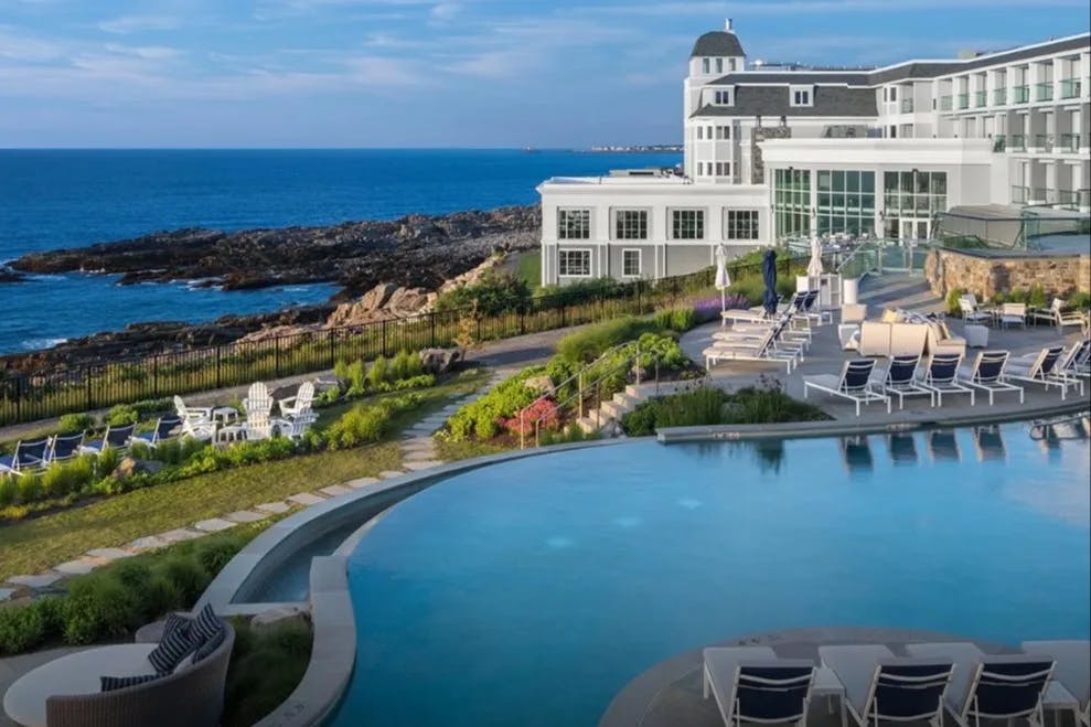 resort with white exterior and a pool overlooking a rocky coastline in Maine