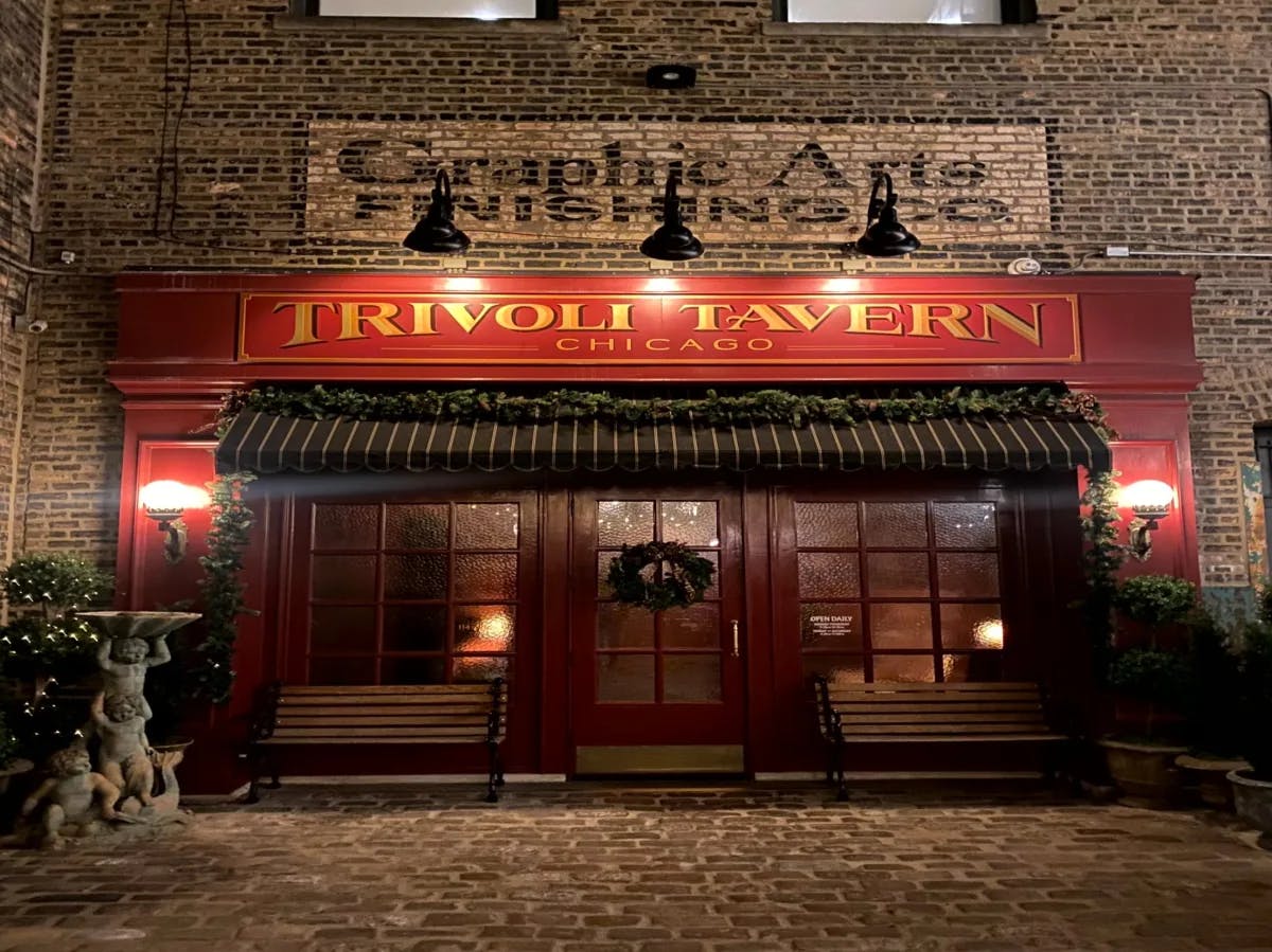 Trivoli Tavern, in a brick building with a red sign, red doors and black awning.