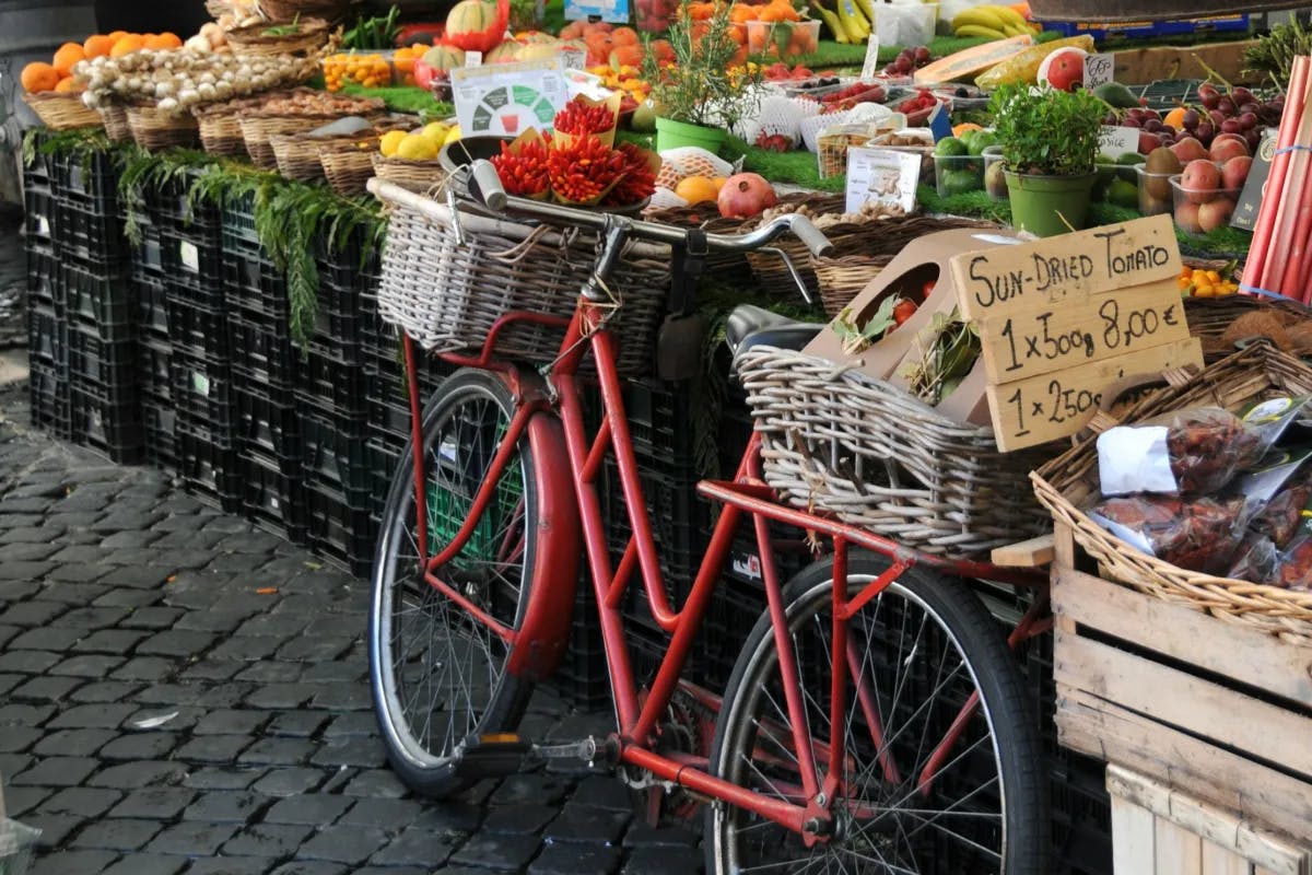 A red bicycle is parked beside the seasonings and spices in a market.