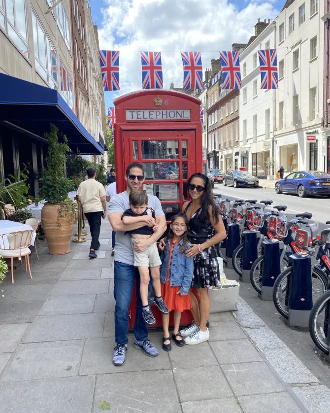 Woman posing with family in front of a red booth