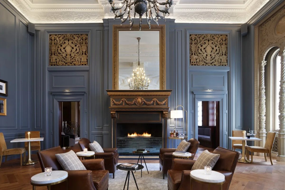 a regal sitting area with a large fire place and teal walls