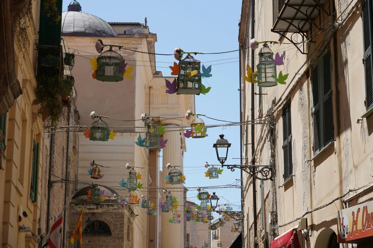 A medieval town with colorful lanterns strung above a street.