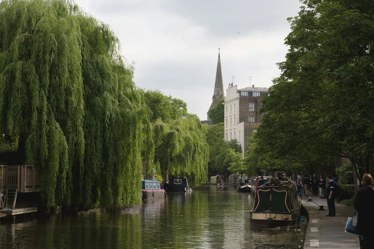 A tranquil canal scene, where nature and urban life converge gracefully along the water’s edge.