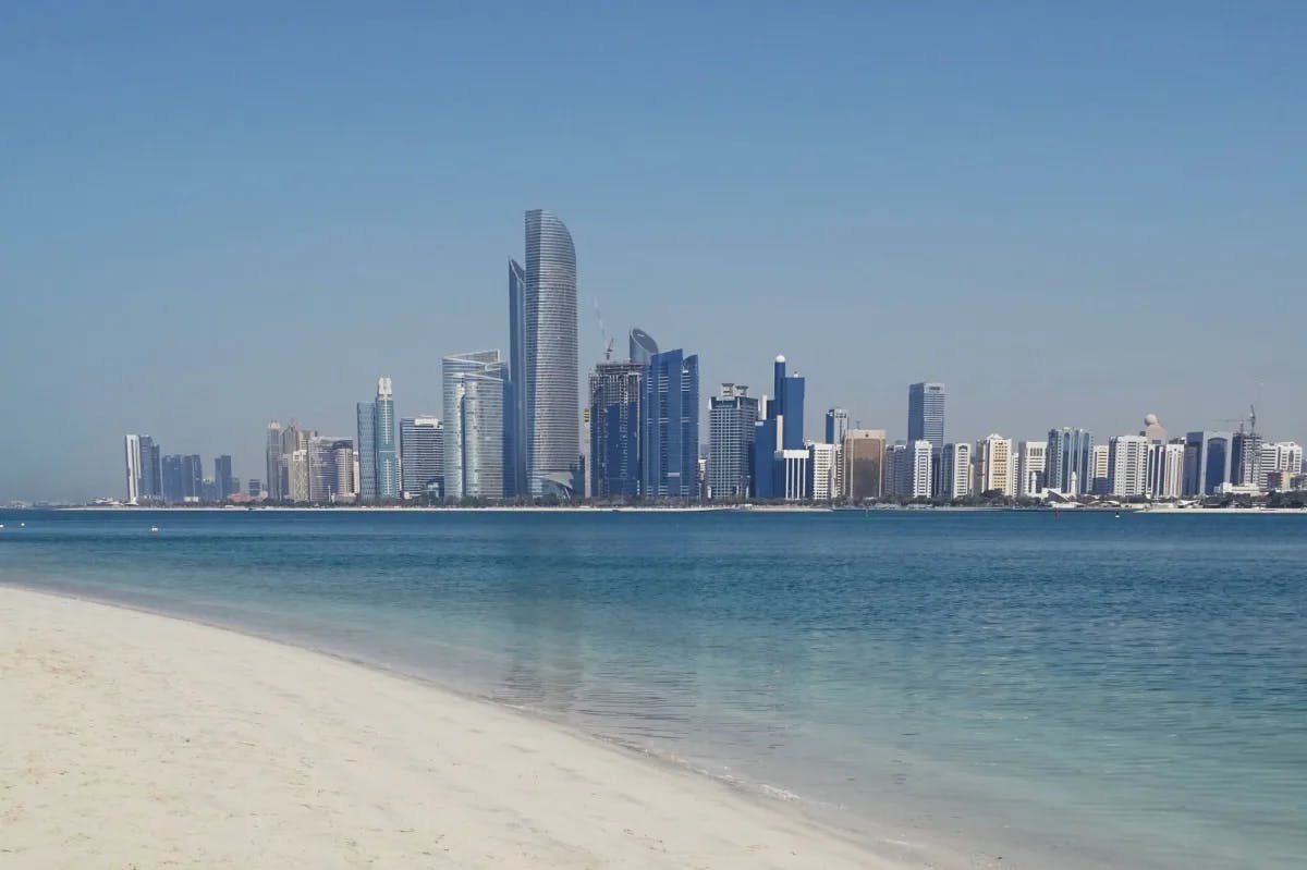 Beach with city skyline during daytime.