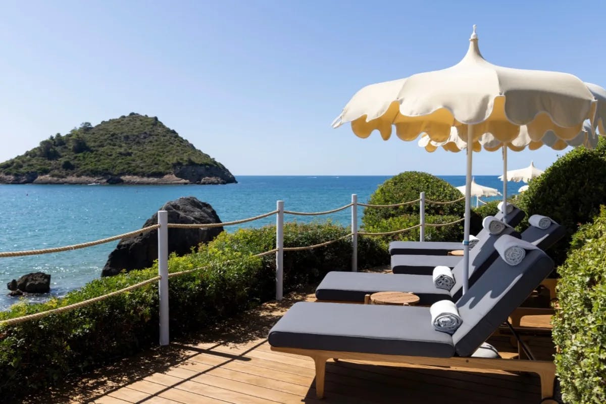 sun loungers on a patio with a view to the sea in Italy