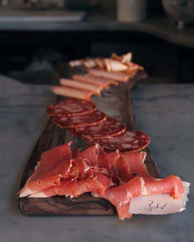 Salumi board of freshly sliced salami, prosciutto, and ham in Italy.