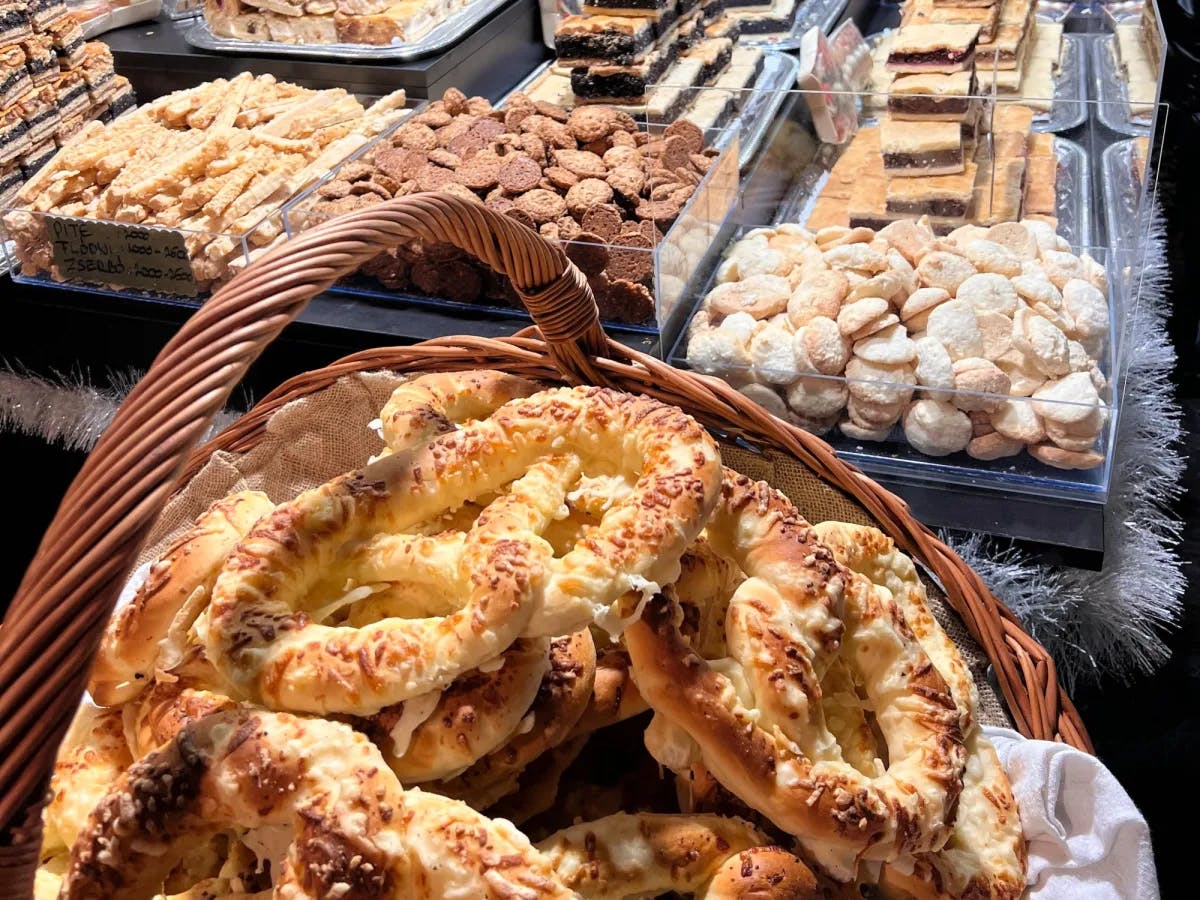 A display of sweet and savory pastries in woven baskets and acrylic containers. 