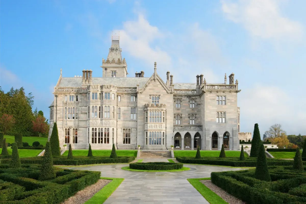 a regal stone castle with a manicured green lawn