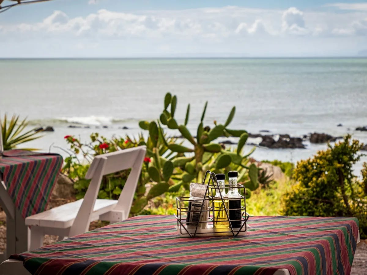 A serene seaside repast, where the ocean’s whisper complements the outdoor restaurant.