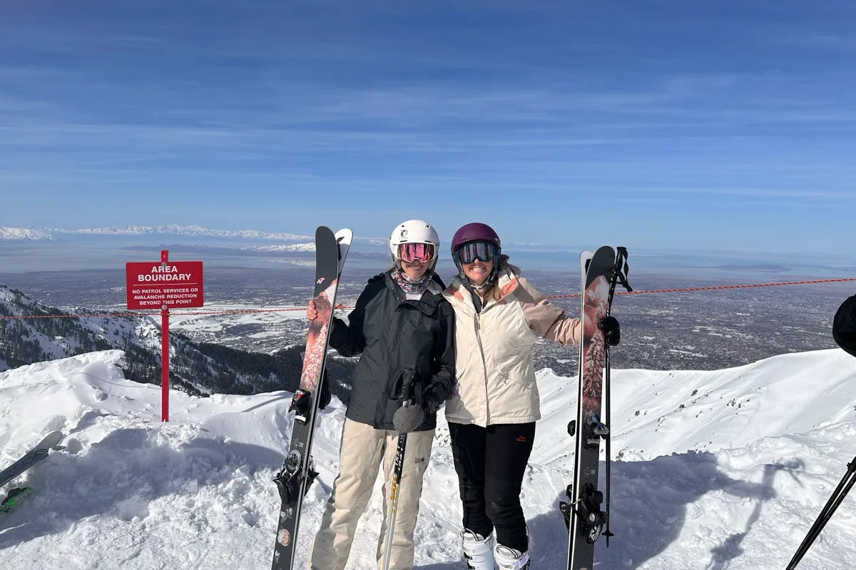 A picture of two people posing at Snowbasin Ski Resort during the daytime.