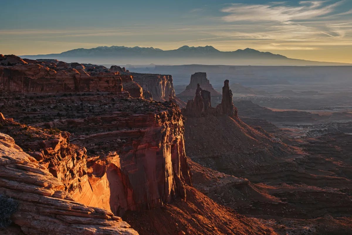 A view overlooking canyons and rock formations at sunset aka "orange hour" as it glows orange.